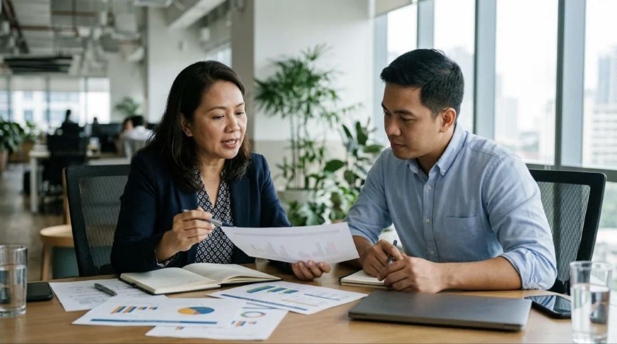 An actuary walks a client through valuation results at a meeting table.